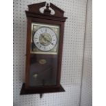 A modern mahogany cased wall clock, 23" high