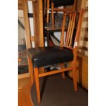 A set of four Gordon Russell teak vertical rail back dining chairs with stuffed over seats,