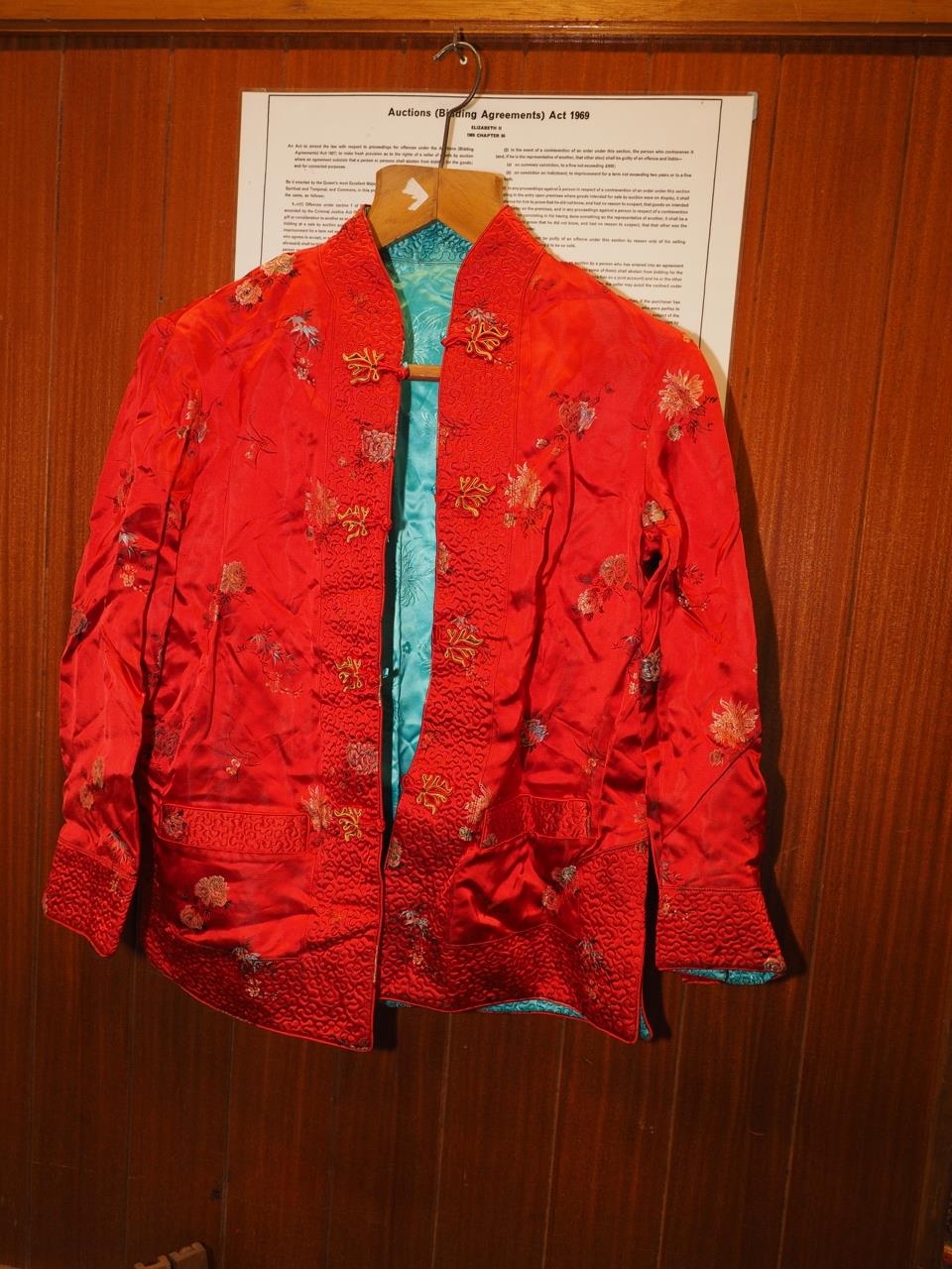 A Chinese silk and fur jacket, embroidered with mythical beast and plant designs on a blue ground,
