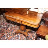 A 19th century rosewood fold-over card table, on quadraform lion claw supports, 36" wide