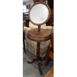 An early 20th century walnut shaving stand with tilting mirror, on tripod splay support, 54" high