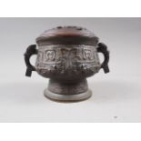 A Chinese brass two-handled censer or archaic design with carved hardwood cover, six-character