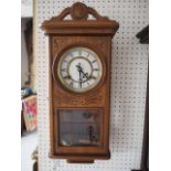 A 1930s carved oak cased wall clock with eight-day striking movement, 21" high