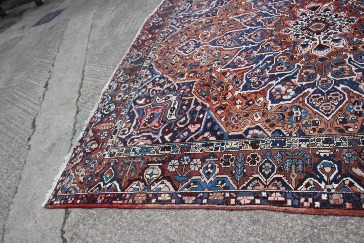 A Hamadan carpet with central star design, on a salmon ground, in shades of blue, brown, pink, - Image 5 of 14