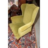 A wing armchair with horse hair upholstery in a green velour, on carved cabriole supports