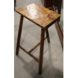 A 19th century burr maple and pine stool, on three faceted supports united by a 'T' stretcher