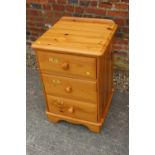 A pine bedside chest of three drawers, on bracket feet, 19" wide x 18" deep x 28" high, and a