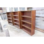 A set of three walnut open four-tier bookcases, on block bases, 36" wide x 11" deep x 52" high