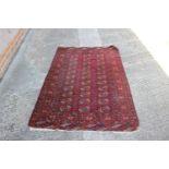 A Bokhara rug with thirty-three guls on a red ground with multi-borders in shades of green, orange