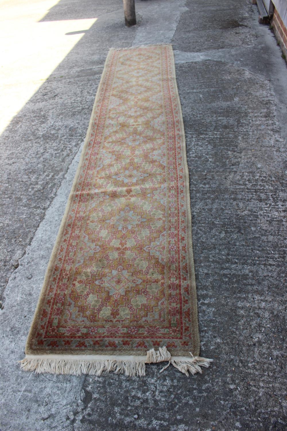 A cotton pile runner with eight central medallions and geometric designs on a natural ground in