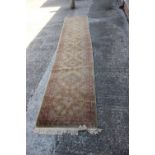 A cotton pile runner with eight central medallions and geometric designs on a natural ground in