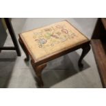 A polished as walnut stool with needlework seat, on cabriole supports and pad feet, 20" wide x 16"