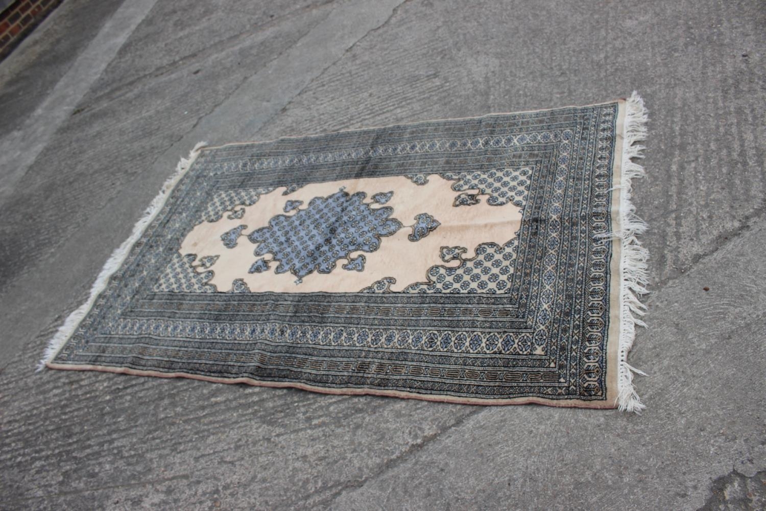 A Middle Eastern rug with central medallion and multi-borders in shades of natural and grey, 59" x