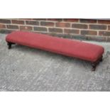 An early 20th century carved walnut fender stool, on scroll supports, 46" long x 10" wide x 7" high