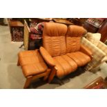 An Ekornes teak frame leather two-seat settee, 55" wide, and matching box seat stool