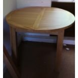 A light oak circular extending dining table, on square supports, 42" dia x 30 3/4" high