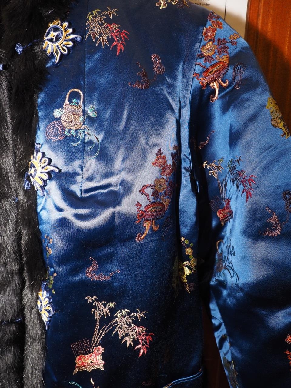 A Chinese silk and fur jacket, embroidered with mythical beast and plant designs on a blue ground, - Image 4 of 4