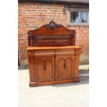 A late Victorian carved mahogany ledge back chiffonier, fitted frieze drawer and cupboards, on block
