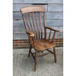 A Windsor lath back farmhouse elbow chair with elm panel seat and turned ash supports