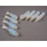 A set of four Danielo opalescent glass knife rests, formed as dogs, 4" long, and a similar set of
