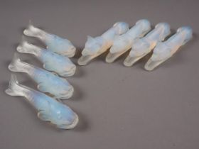 A set of four Danielo opalescent glass knife rests, formed as dogs, 4" long, and a similar set of