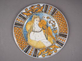 An Italian plate, decorated with a nude woman playing the violin (chip to rim)