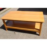 An Ercol light oak two-tier coffee table, 43" wide x 24" deep x 18" high