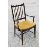 An Edwardian polished as mahogany spindle back elbow chair, seat upholstered in a gold fabric, on