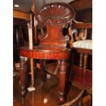 An early 19th century Gillows design mahogany carved shell back hall chair, on turned and reeded