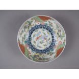 A Chinese porcelain bowl with central decoration of a mythical beast and foliate borders, 11" dia