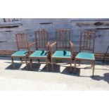 A set of four Edwardian walnut and inlaid vertical rail back dining chairs with padded seats, on