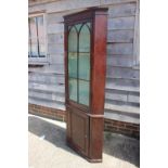A 19th century mahogany floor standing corner cupboard, the upper section enclosed glazed door