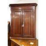 A 19th century oak and mahogany banded corner hanging cupboard enclosed two doors, 32" wide x 18"