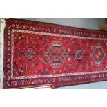A Hamadan runner with star medallions on a red ground, 150" x 29" approx