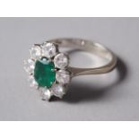 An 18ct white gold, emerald and diamond cluster ring, set central oval emerald surrounded eight
