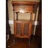 A smoker's Arts & Crafts carved oak side cabinet with tray top over one drawer and fitted interior