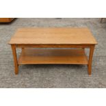 An Ercol ash two-tier coffee table, on shaped supports, 36 1/2" wide x 19 3/4" deep x 16 3/4" high