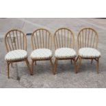 A set of four Ercol elm hoop and spindle back dining chairs, on splay supports with cushions