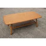 An Ercol elm low coffee table with spindle under-tier, on splay supports, 41" wide x 19" deep x 14