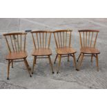 A set of four Ercol 449 ash bow and spindle back dining chairs, on turned and stretchered
