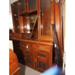 An Edwardian carved walnut sideboard/dresser, the upper section fitted four glazed doors and central