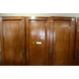 A 19th century French walnut inverse breakfront wardrobe enclosed four panel doors, on turned