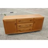 An Ercol 455 elm sideboard, fitted three centre drawers and flanking cupboards, 61 1/2" wide x 18"