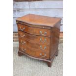 A bachelor's walnut and banded serpentine front chest, fitted side drawer and cupboard, on bracket