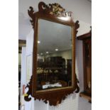 A carved walnut and gilt wall mirror of early Georgian design with Hoho bird crest, plate 21 1/2"