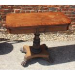 A rosewood and banded fold-over tea table, on carved column and quadraform base with lion paw