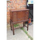 A mahogany drinks cabinet of Georgian design with fall front, on stand with chamfered supports,