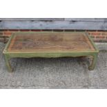 A Chinese carved hardwood and lacquered low glass top coffee table, on shaped supports, 52 1/2" wide
