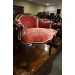 A carved mahogany showframe dressing chair of Louis XVI design, upholstered in a salmon velour, on