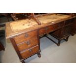 A late 19th century oak double pedestal desk with tooled lined top, fitted five drawers and